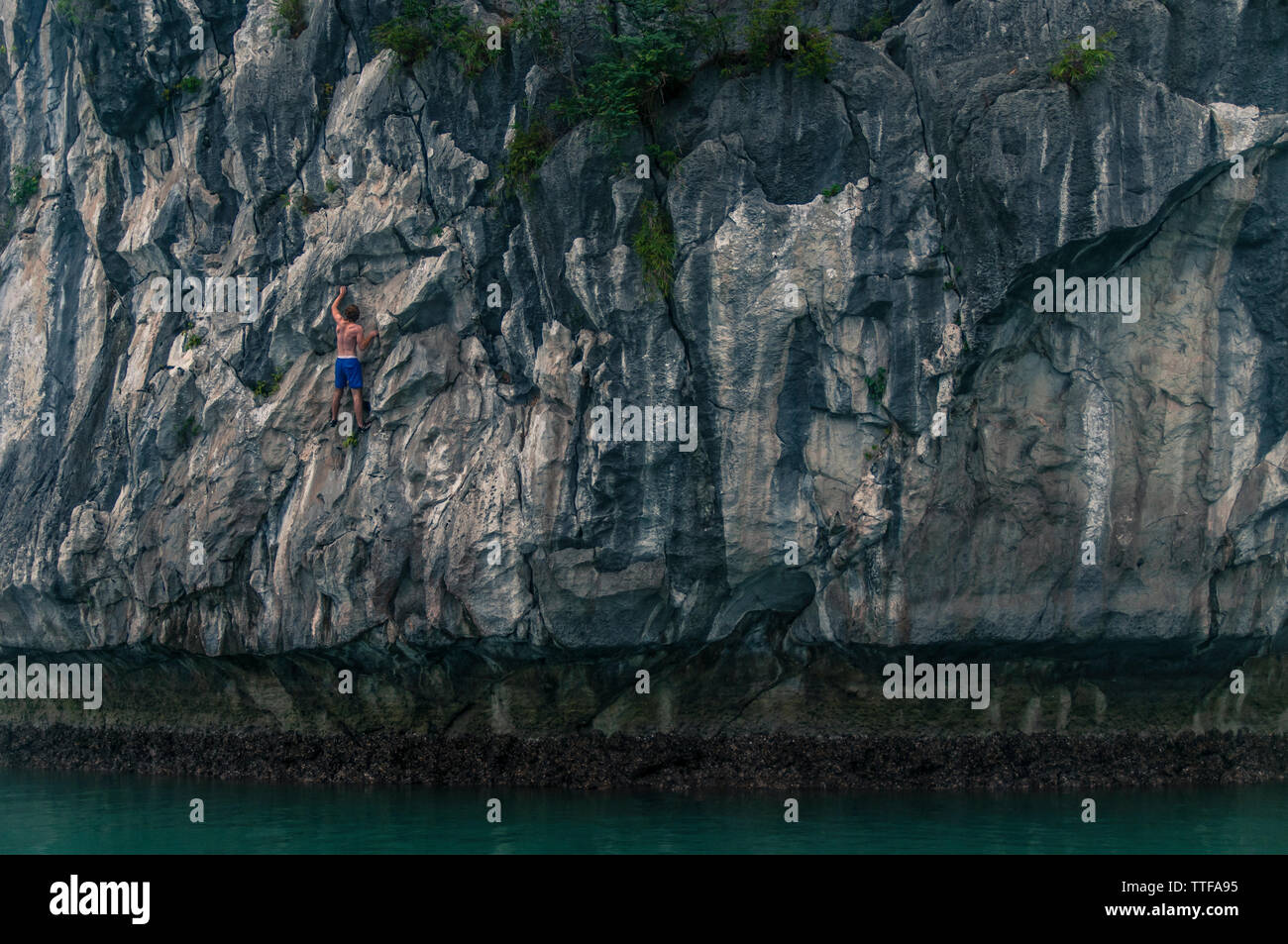 Man Deep Water Soloing über Wasser auf Kalkfelsen Stockfoto