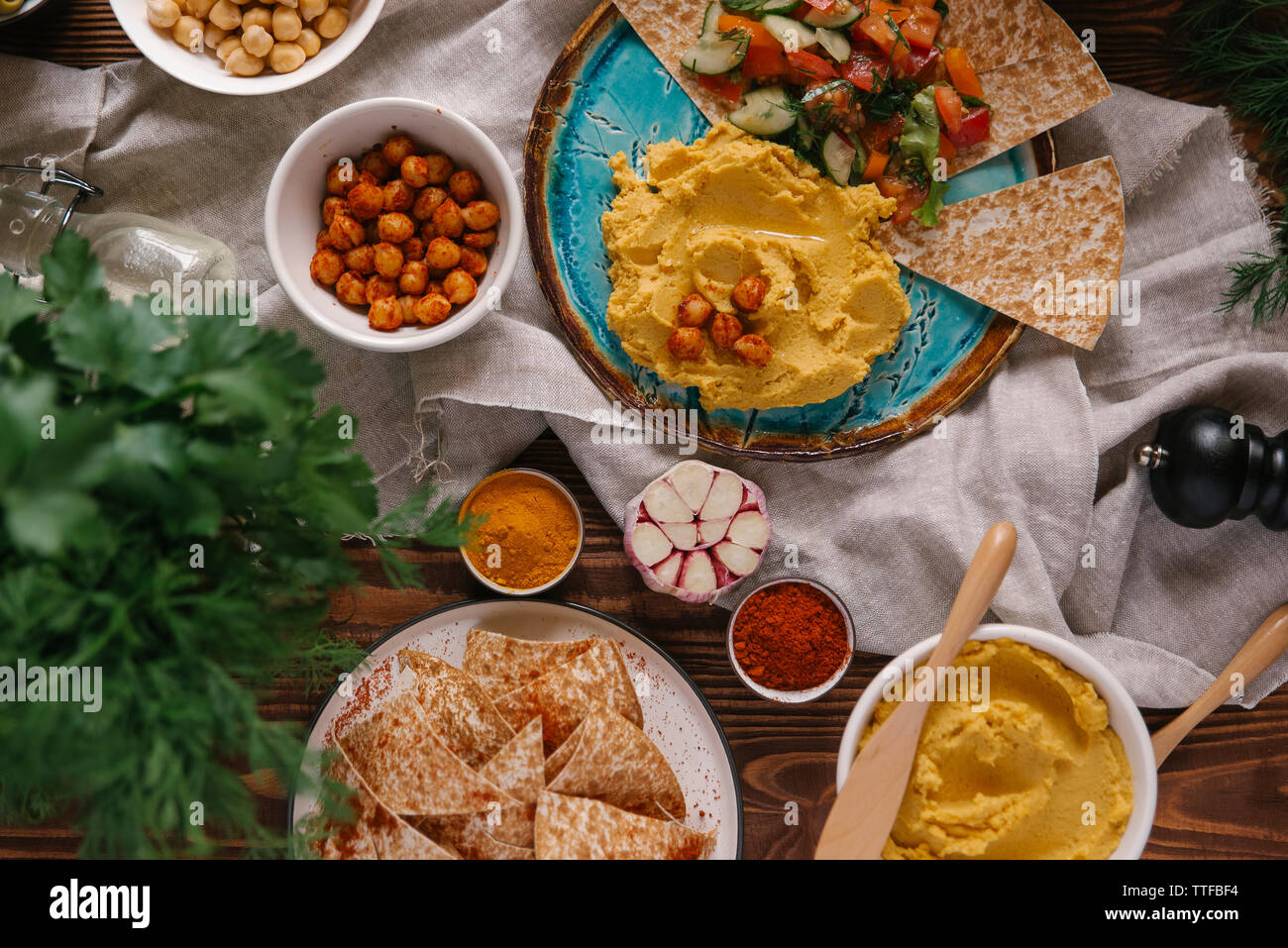 Hohe Betrachtungswinkel verschiedener Lebensmittel mit Serviette auf hölzernen Tisch serviert. Stockfoto