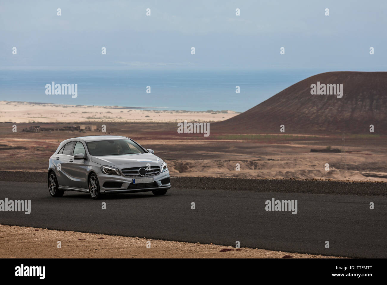 Grau Auto leer gepflasterte Straße in der Wüste Vulkanlandschaft Stockfoto