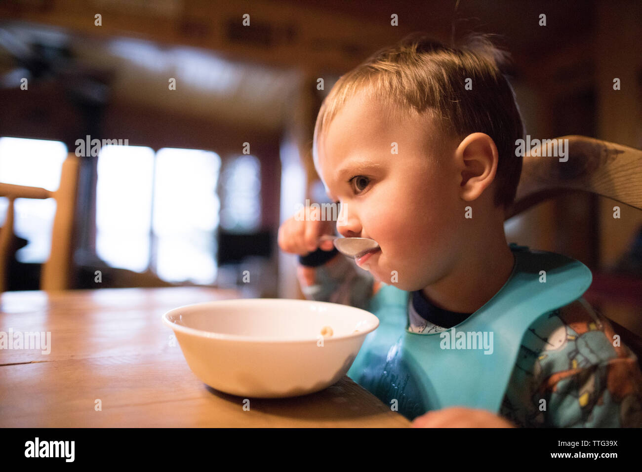 Cute Baby Boy weg schauen, während das Frühstück zu Hause essen Stockfoto