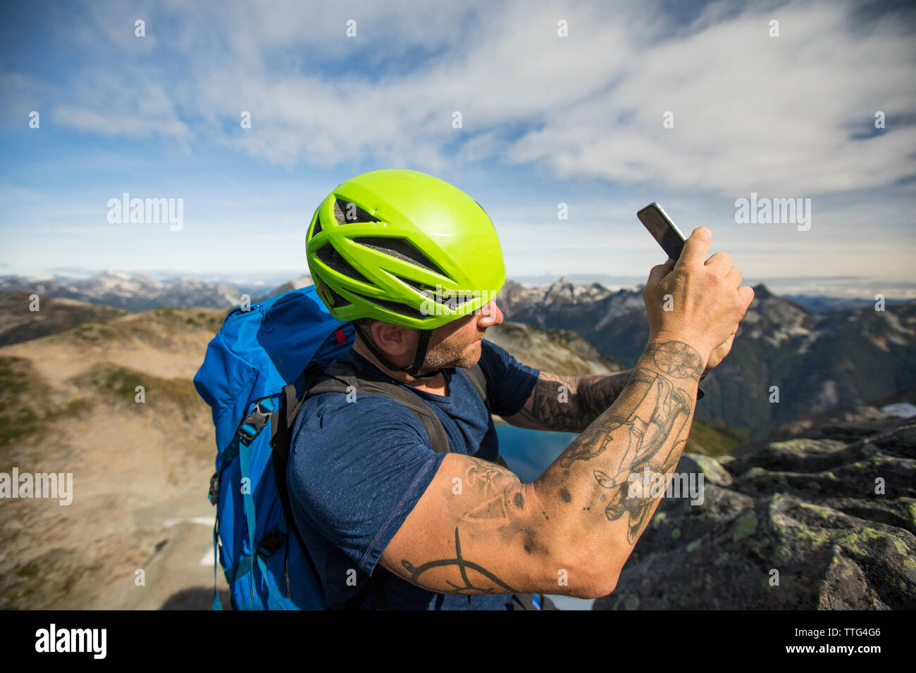 Bergsteiger nimmt Foto mit seinem Smartphone. Stockfoto