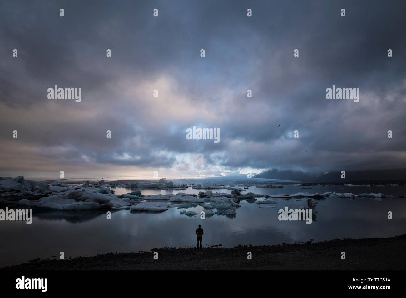 Silhouette-Mann steht auf dem Seeweg gegen Wolkengebilde Stockfoto