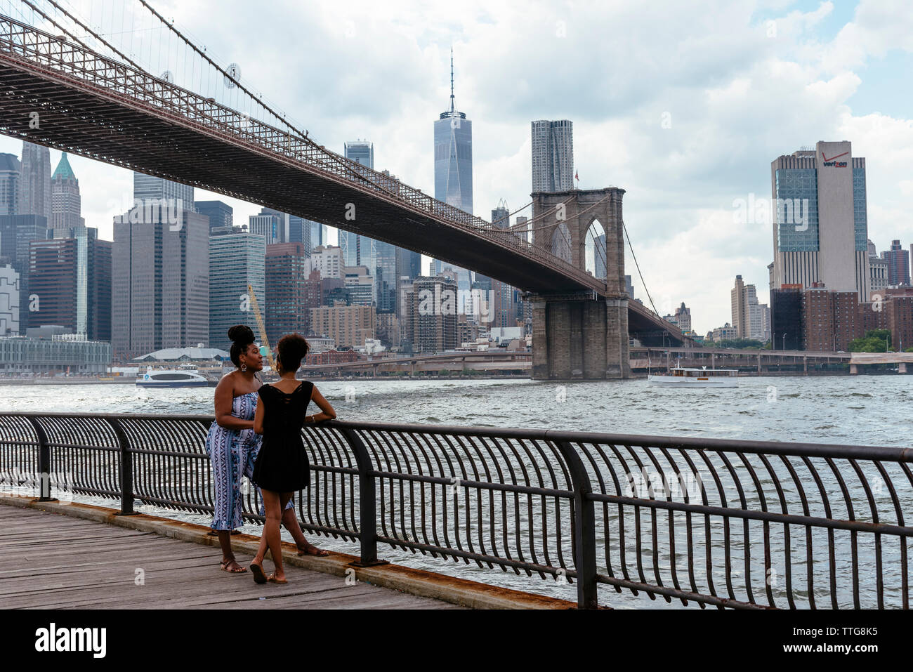 Zwei afro-amerikanische Frauen an der Promenade unter der Brooklyn Bridge In New York Stockfoto