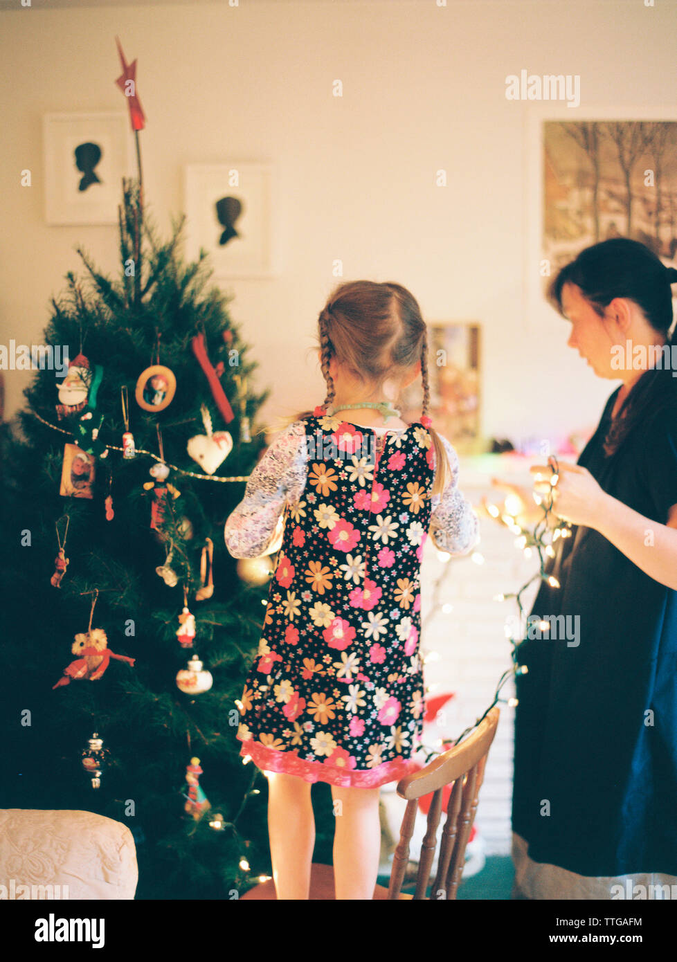 Mutter und Tochter schmücken den weihnachtsbaum Stockfoto