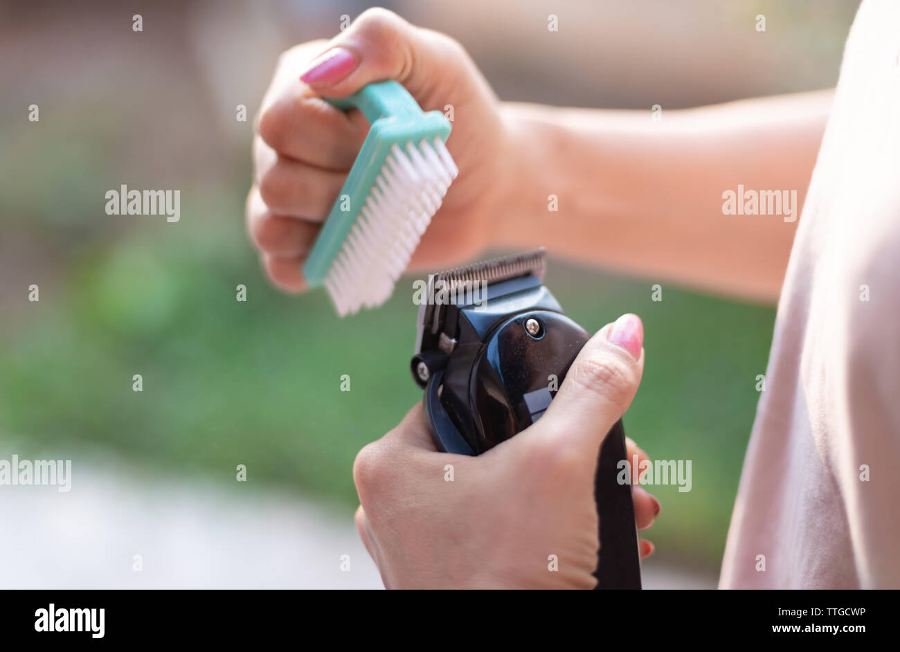Friseur reinigt ein Schermesser mit der Bürste Stockfoto