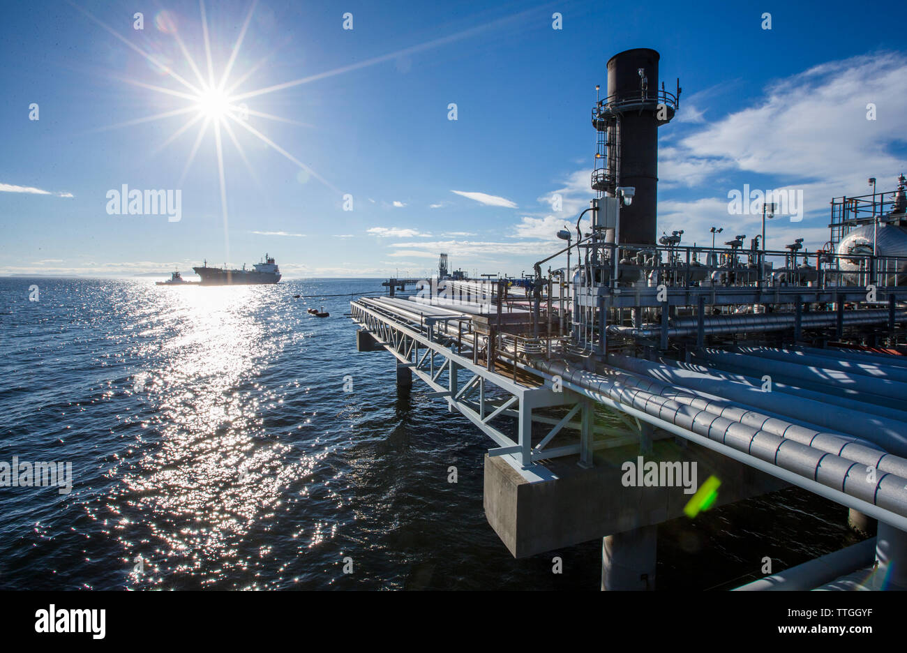 Fabrik durch das Meer gegen den blauen Himmel Stockfoto