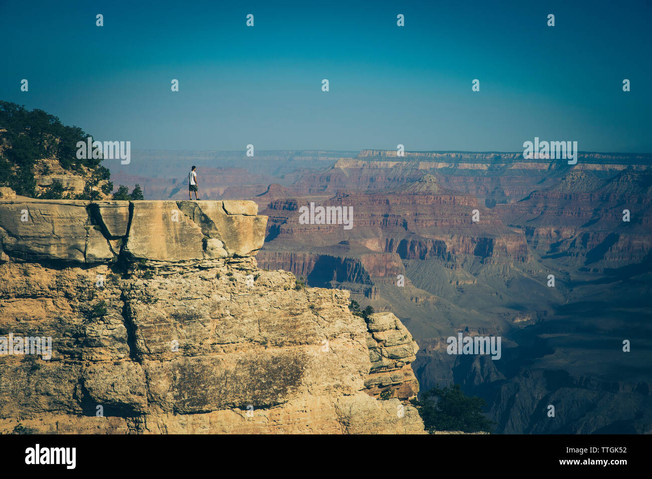 Menschen, die auf dem Felsen bei Sonnenaufgang im Grand Canyon Stockfoto