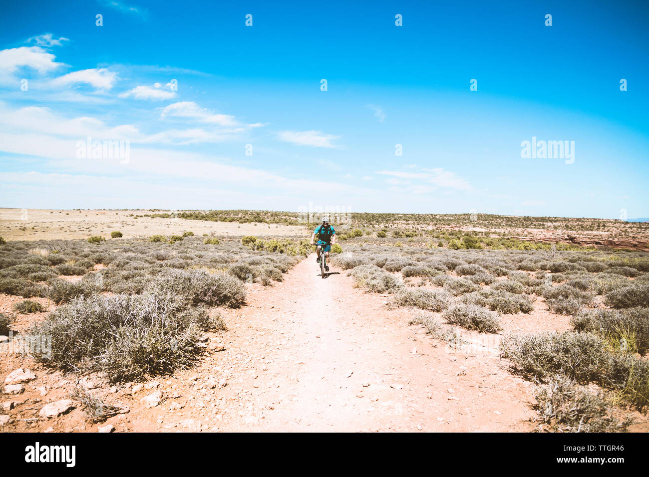 Ältere Menschen Radfahren auf Schmutz Trail gegen den blauen Himmel Stockfoto