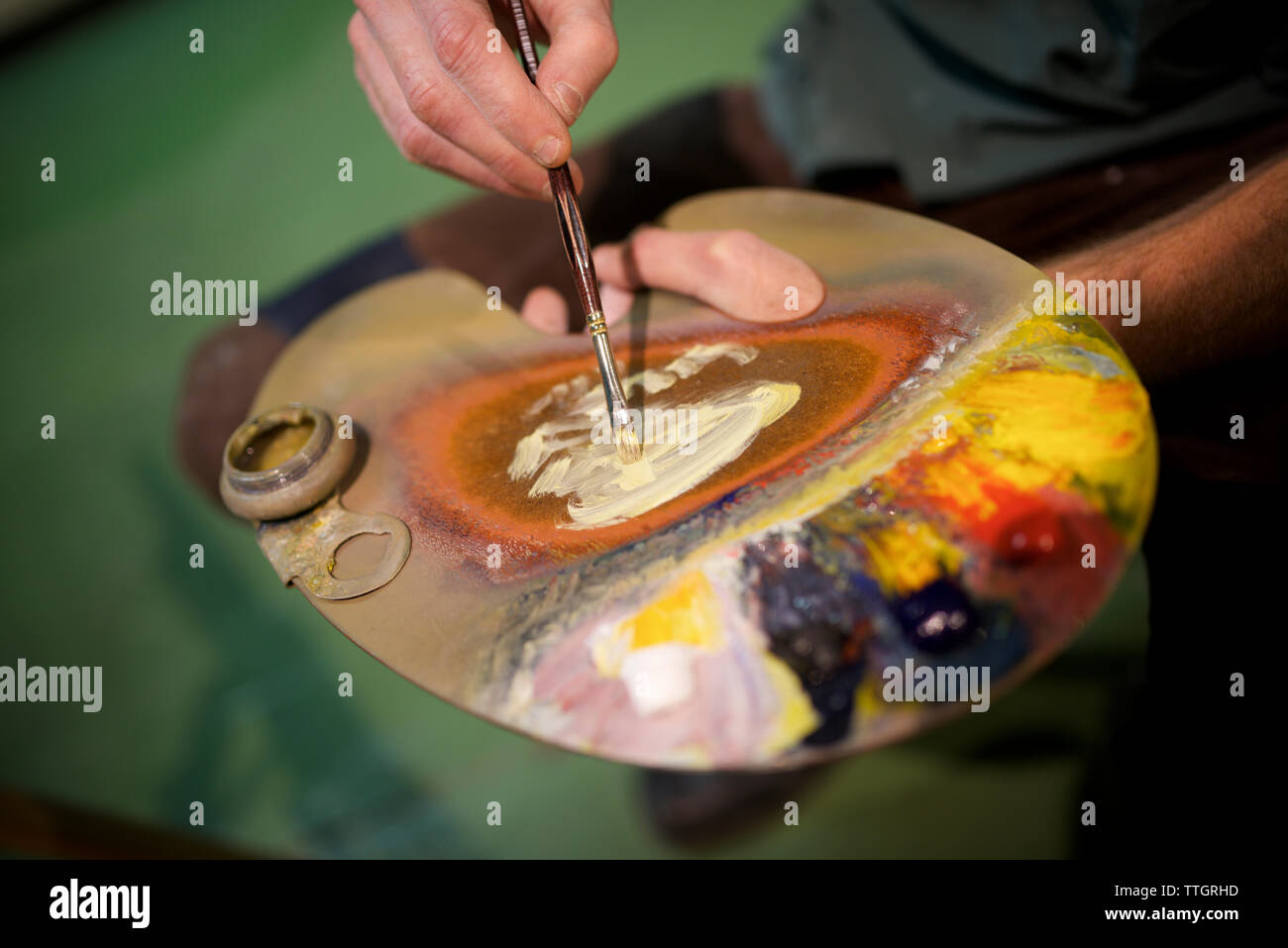 Mittelteil der Mann mit Aquarellfarbe Palette in der Werkstatt Stockfoto