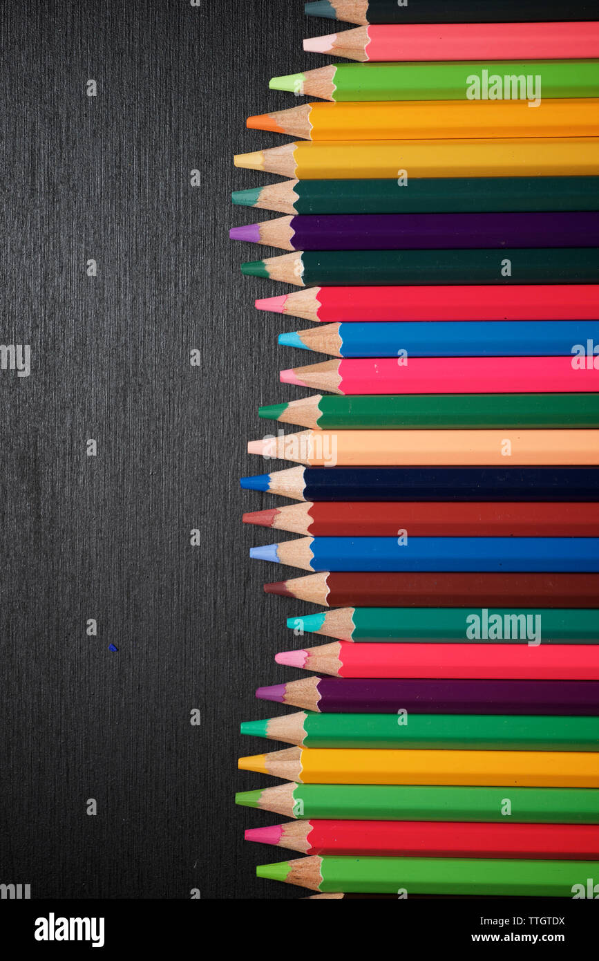 Aquarellstifte aufgereiht auf einem Schwarzen Tisch. Stockfoto