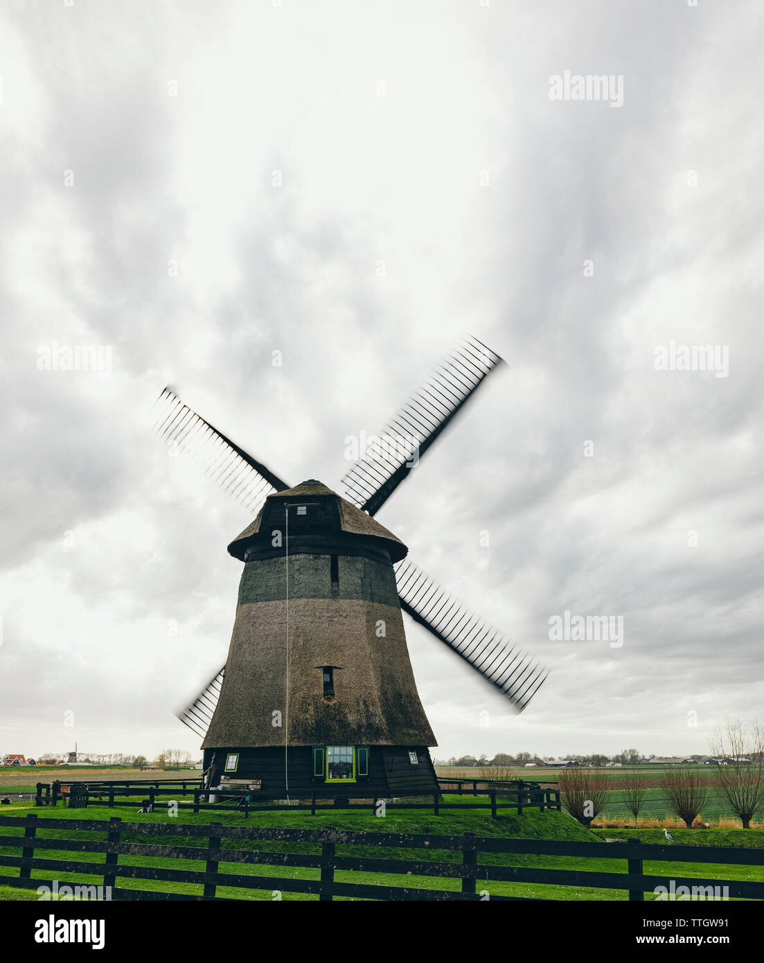 Traditionelle holländische Windmühle in Land in windigen Tag. Stockfoto