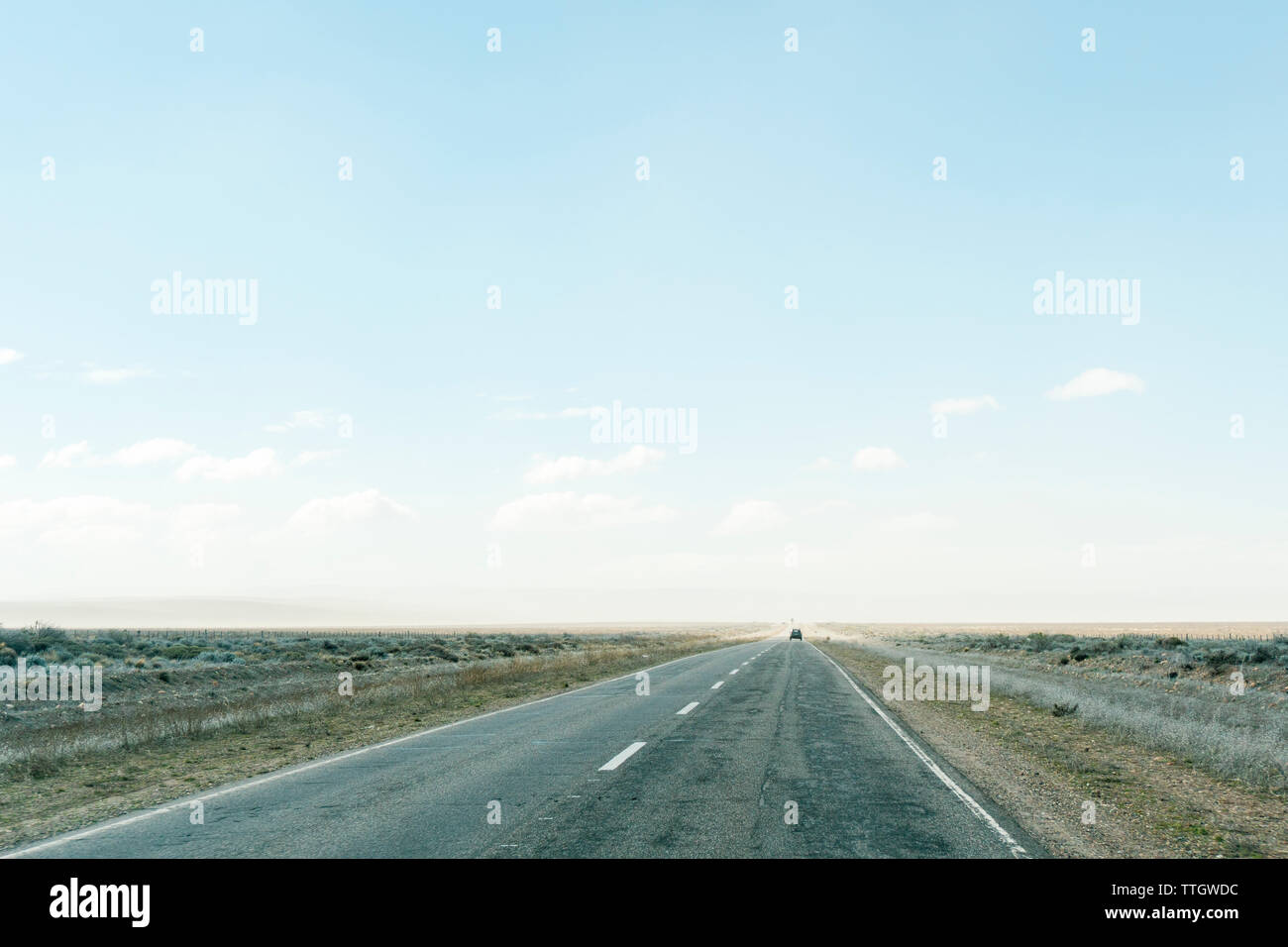Fahrt entlang einer flachen Straße in Argentinien an einem sonnigen Wintertag. Stockfoto