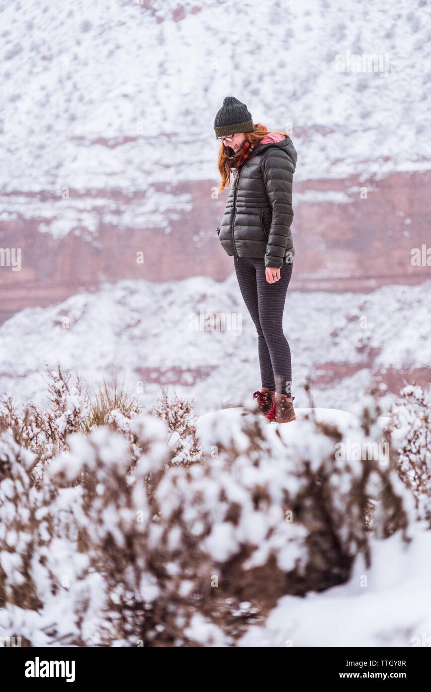 Stilvolle Frau Wandern auf dem verschneiten Winter Desert Trails Stockfoto