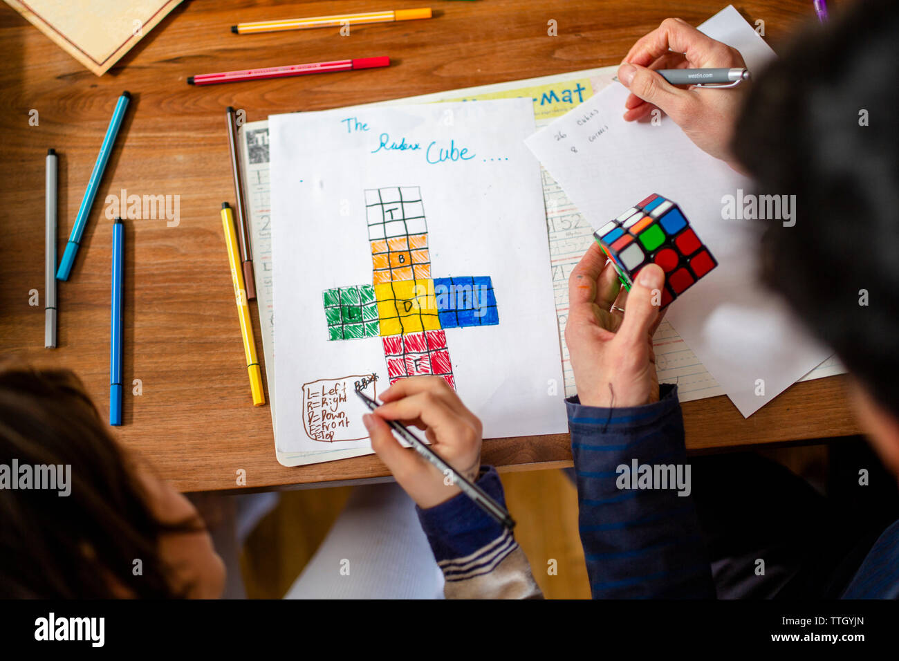 Oben Ansicht von Vater und Kind Lösen eines Puzzles zusammen für Hausaufgaben Stockfoto