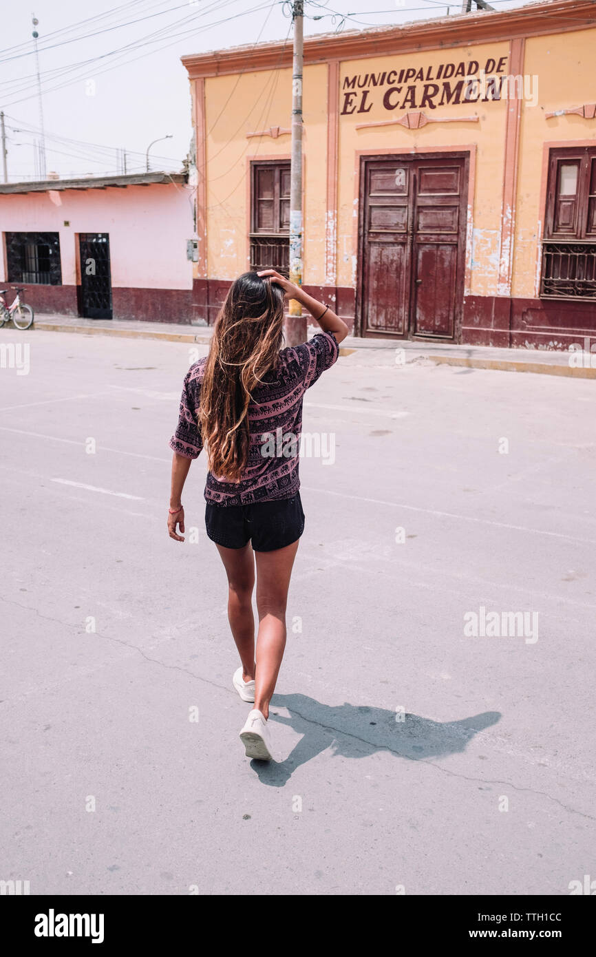 Eine Frau in Freizeitkleidung Spaziergänge auf der Straße, in der Nähe der "El Carmen, Chincha, Peru Stockfoto