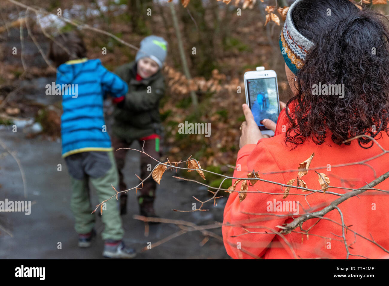 Frau nimmt ihren Sohn und einen Freund mit ihrem Smartphone im Freien Stockfoto