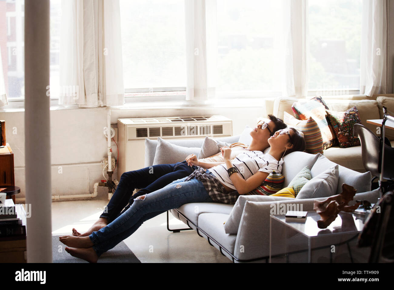 Entspannte junges Paar zurückgelehnt auf dem Sofa zu Hause Stockfoto