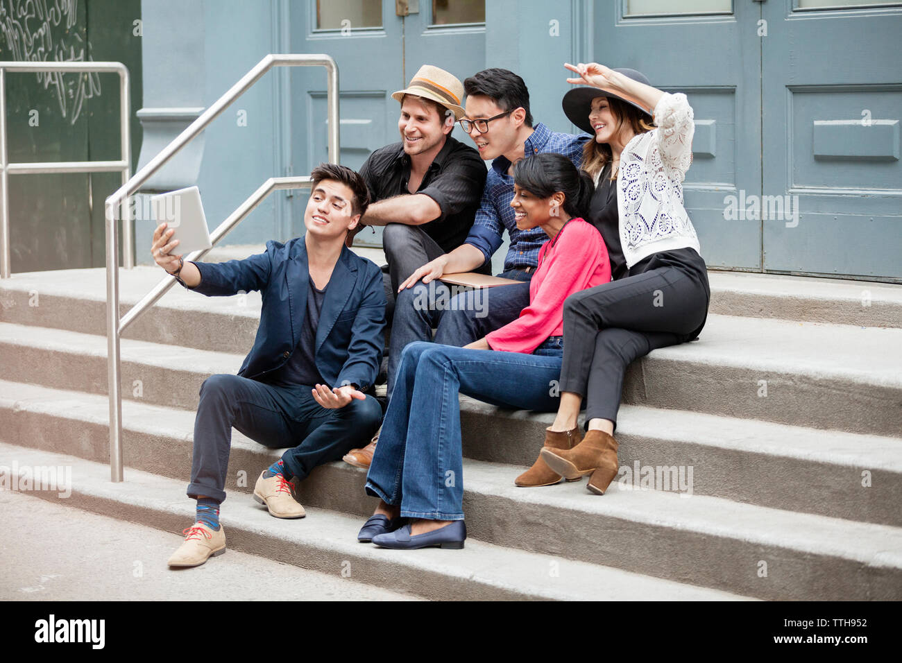 Kreative Geschäftsleute nehmen Selfie sitzend auf Schritte Stockfoto