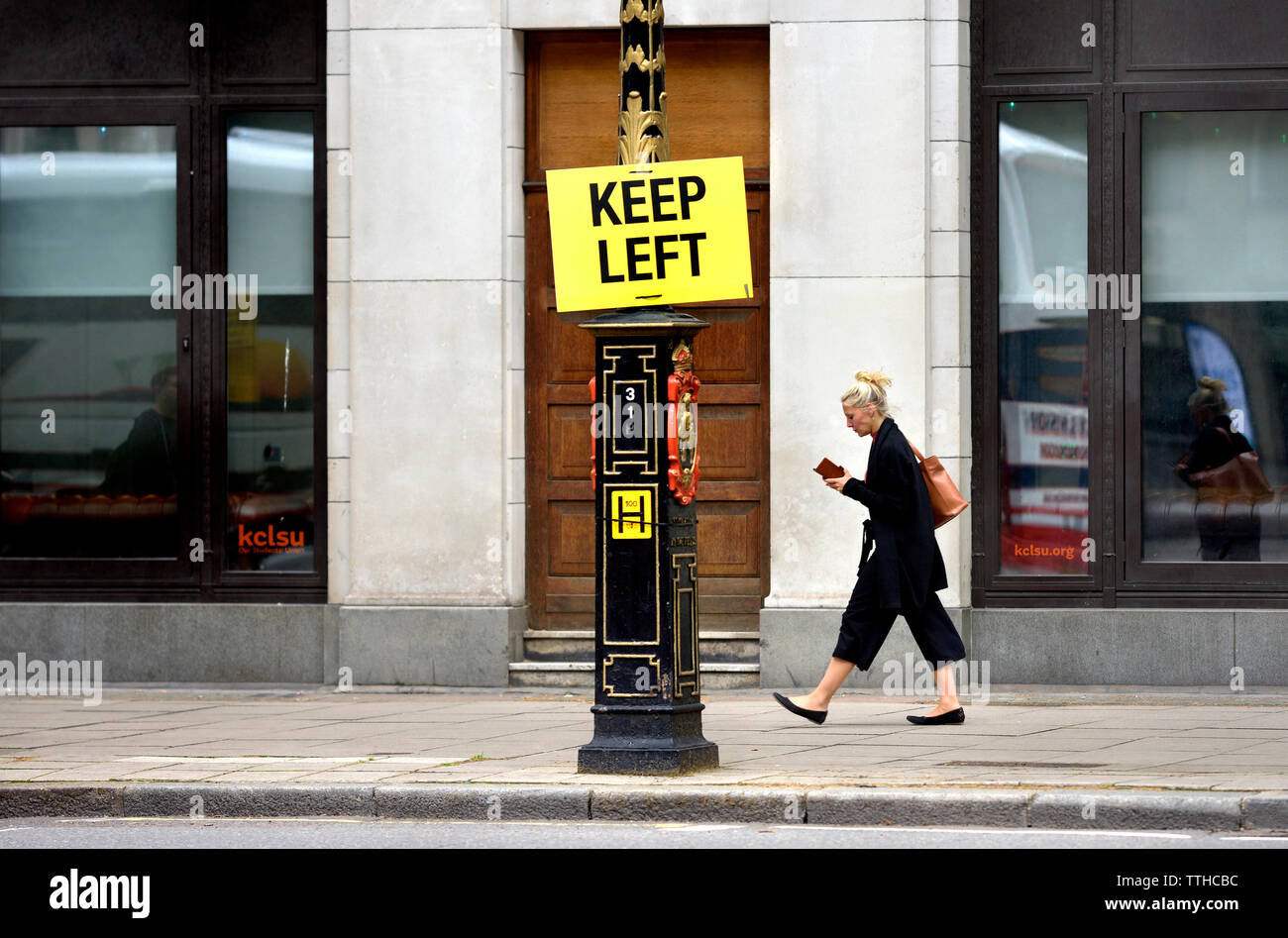 London, England, UK. Links Anmelden Fleet Street halten. Frau auf dem Handy vorbei gehen. Stockfoto