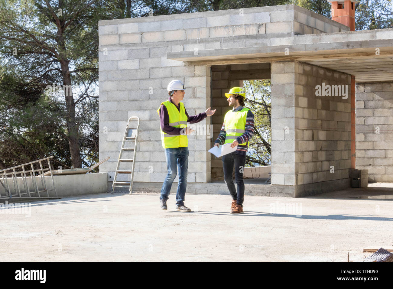 Diskussion zwischen einem Bauleiter und dem Architekten während der Baustelle Besuch von einem Haus im Bau Stockfoto