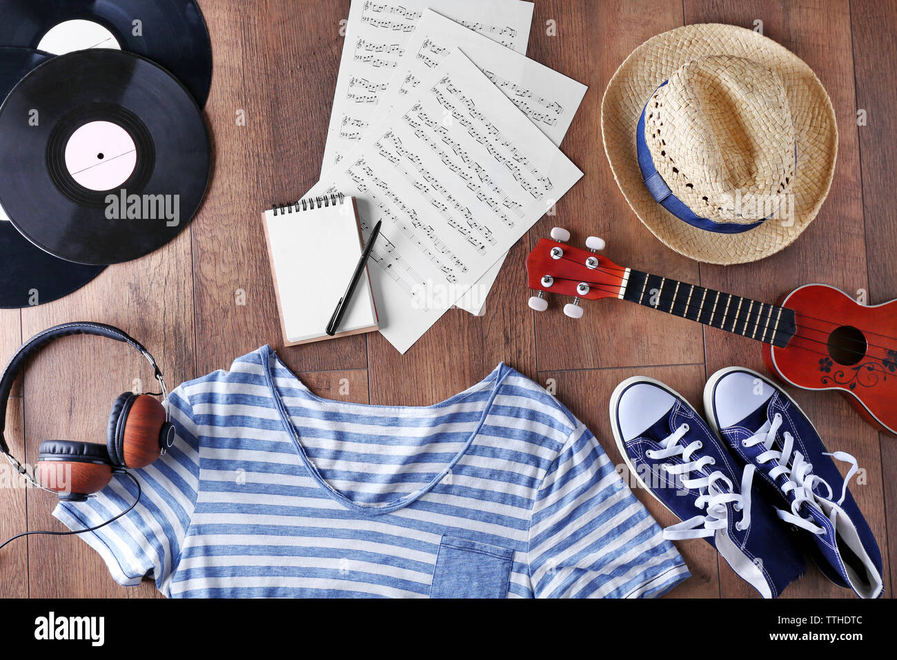 Gitarre, Kopfhörer, Musik Bettwäsche und Kleidung auf Holz- Oberfläche, Ansicht von oben Stockfoto