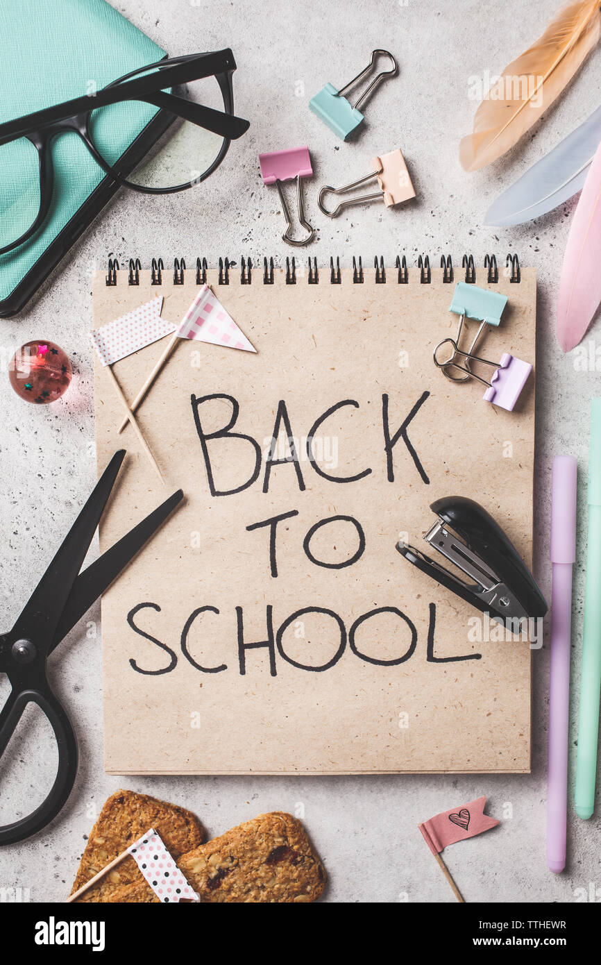 Notebook, Brillen, Kugelschreiber, Schreibwaren und Bürobedarf Objekte auf einem grauen Hintergrund, Ansicht von oben. Zurück Konzept zur Schule, Hintergrund. Stockfoto