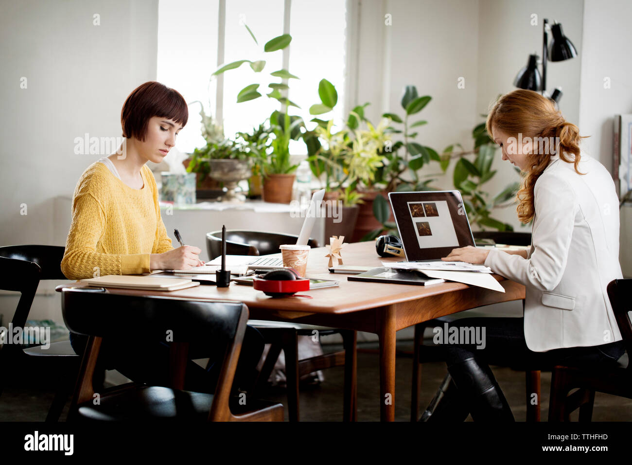 Weibliche foto Redaktion am Tisch arbeiten in kreativen Büro Stockfoto