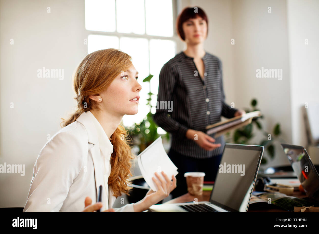 Weibliche Foto-Editoren diskutieren im Sitzungsraum Stockfoto