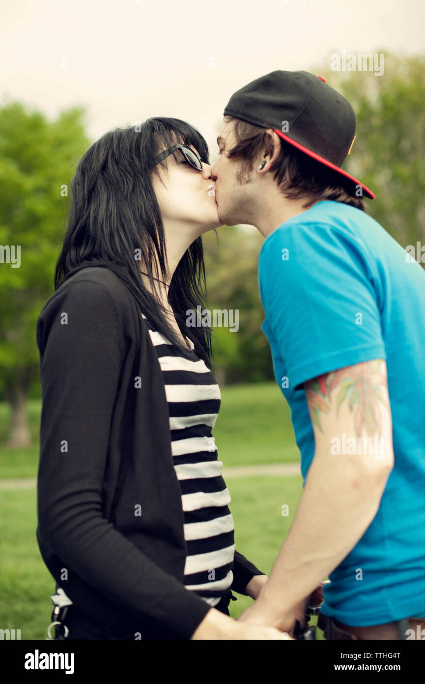 Paar küssen beim Stehen im Park Stockfoto