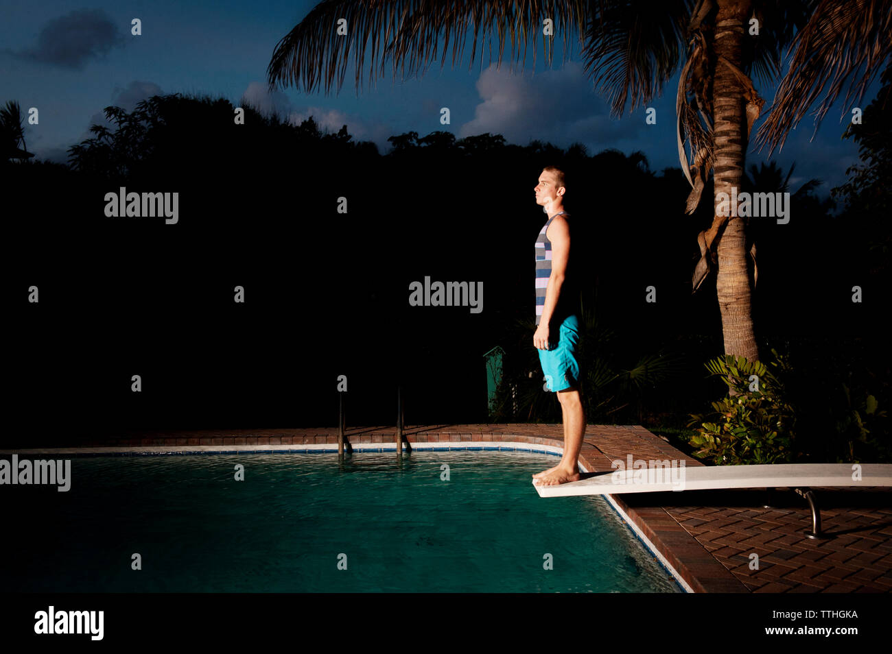 Seitenansicht der Mann stand am Sprungturm auf Swimming pool Stockfoto