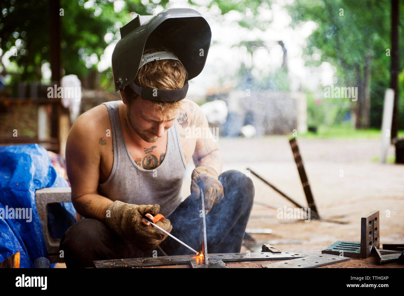 Konzentrierter Arbeiter Schweißen außerhalb der Werkstatt Stockfoto