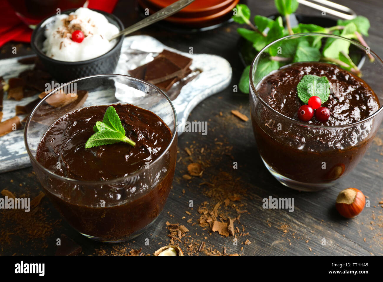 Glas Tassen Schokolade Dessert mit frischer Minze auf schwarzen Holztisch Stockfoto