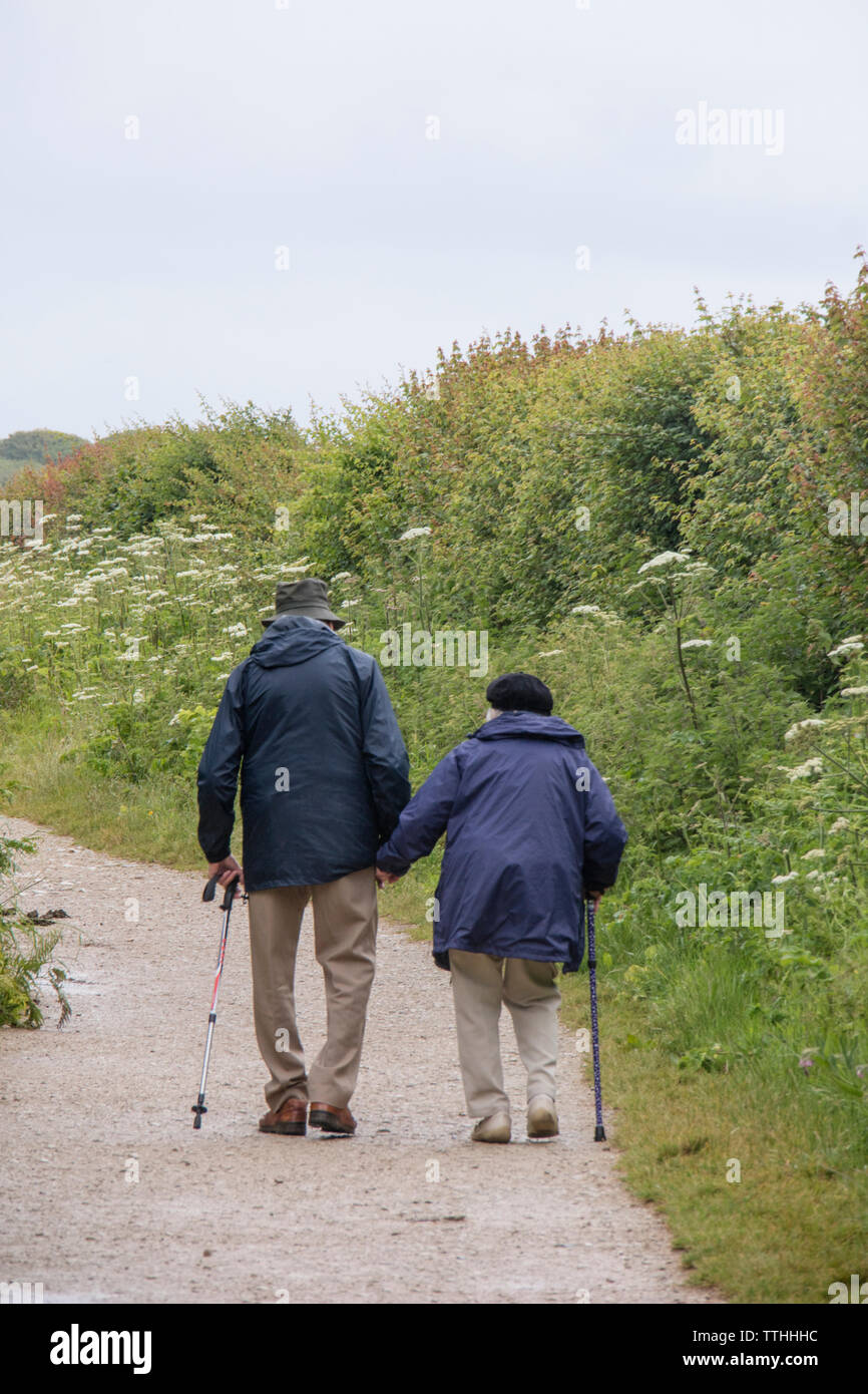 Ältere Paare gehen der South West Coastal Path in Richtung Handfast Point und Old Harry Rocks, Dorset, England, Großbritannien Stockfoto