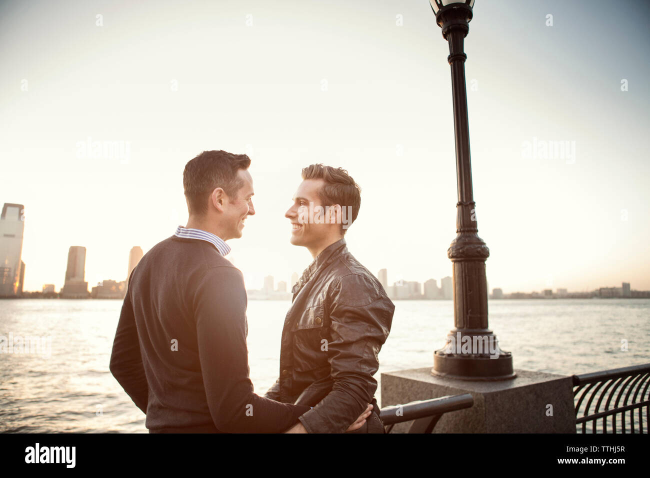 Glücklich homosexuelle Paare stehen Fluss gegen Sky Stockfoto