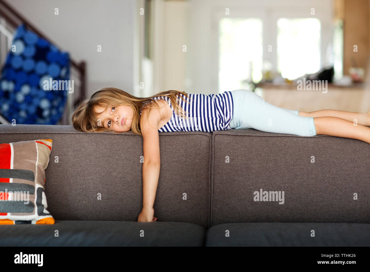 Portrait von gelangweilten Mädchen liegt auf dem Sofa zu Hause Stockfoto