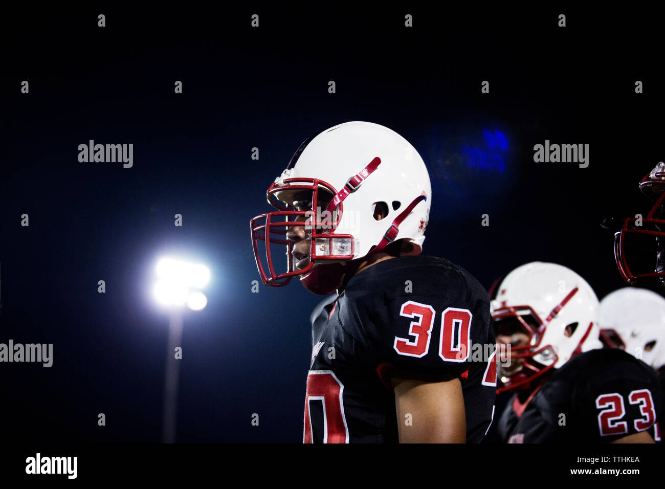 Low Angle View von Teenage American Football Spieler gegen Himmel bei Nacht Stockfoto