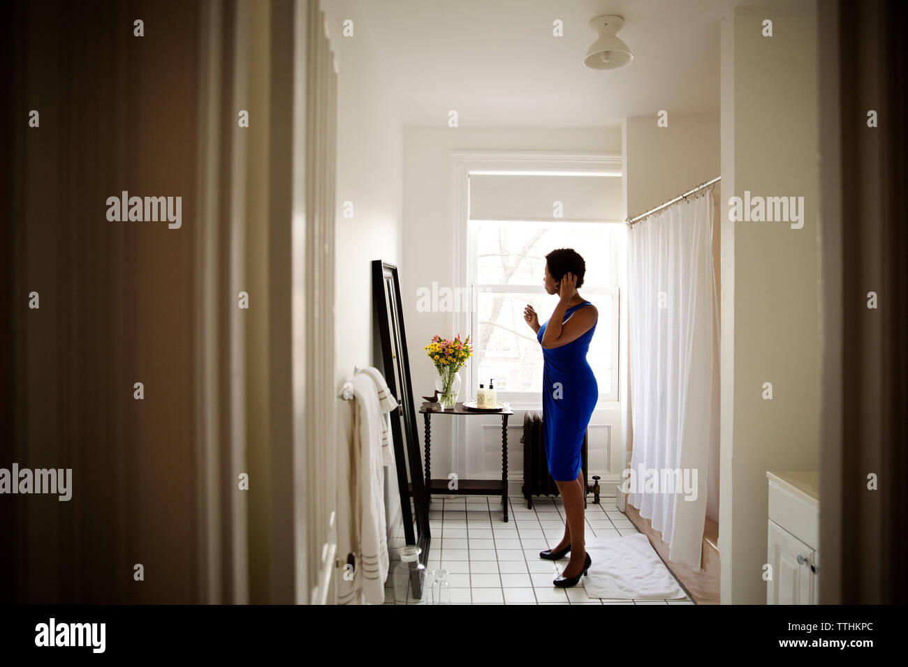 Seitenansicht von Frau im Spiegel und zu Hause angezogen Stockfoto