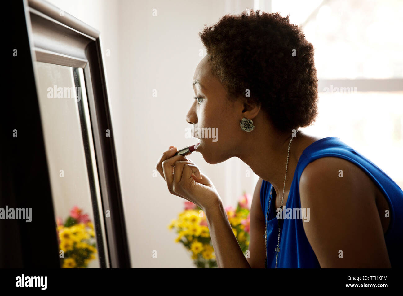Nahaufnahme der jungen Frau Anwendung Lippenstift zu Hause Stockfoto