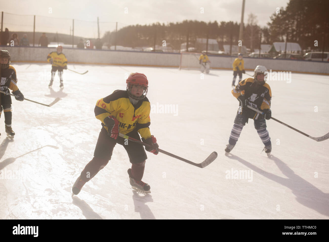 Jungen spielen Eishockey an einem sonnigen Tag Stockfoto