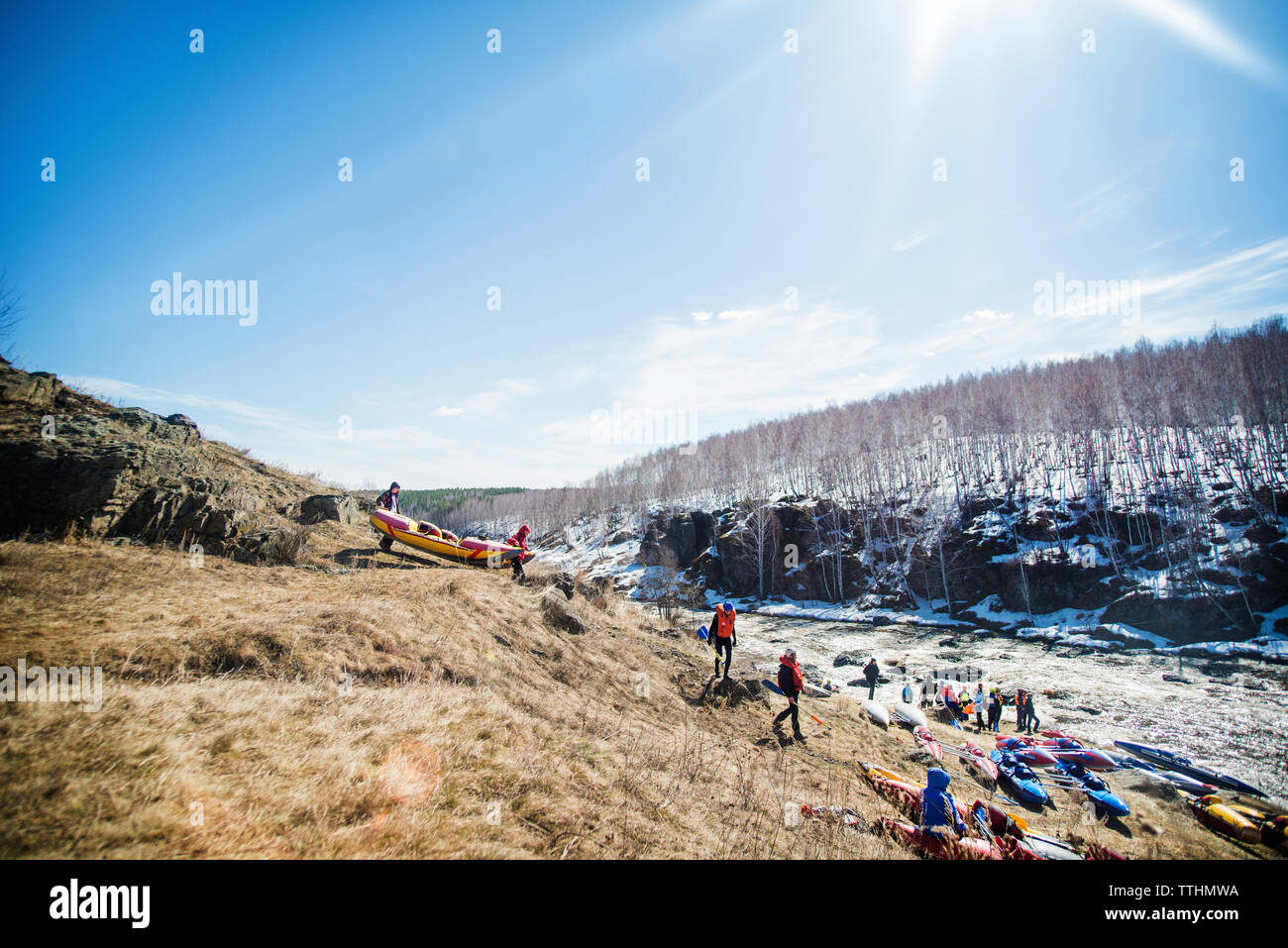 Freunde, die Boote auf einem Hügel am Fluss während der sonnigen Tag Stockfoto