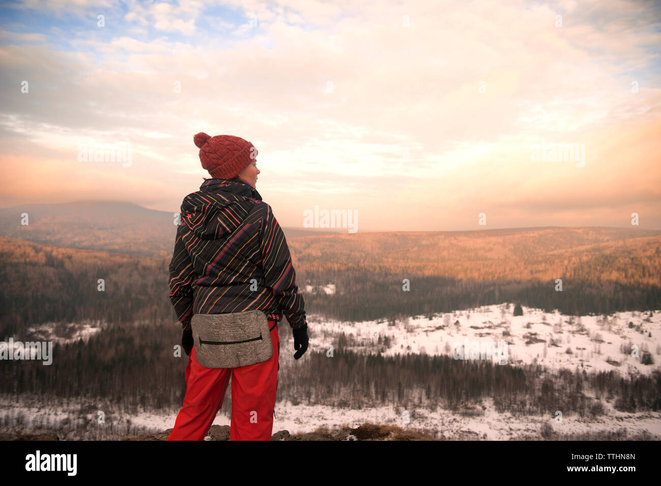 Frau, die auf dem Berg im Winter gegen bewölkter Himmel Stockfoto