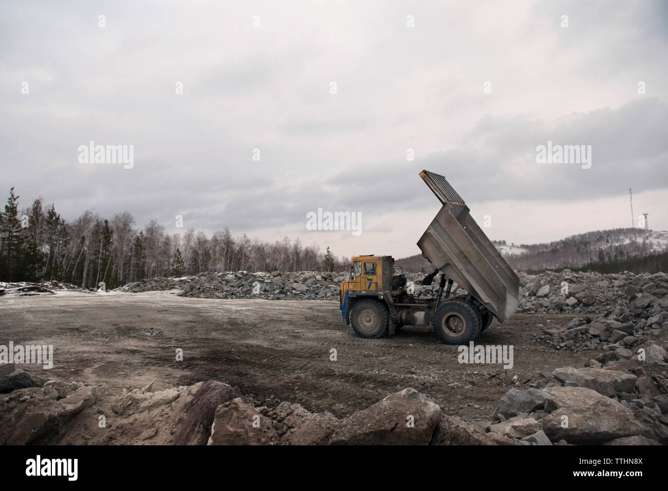 Dump Truck auf Feld gegen bewölkter Himmel Stockfoto