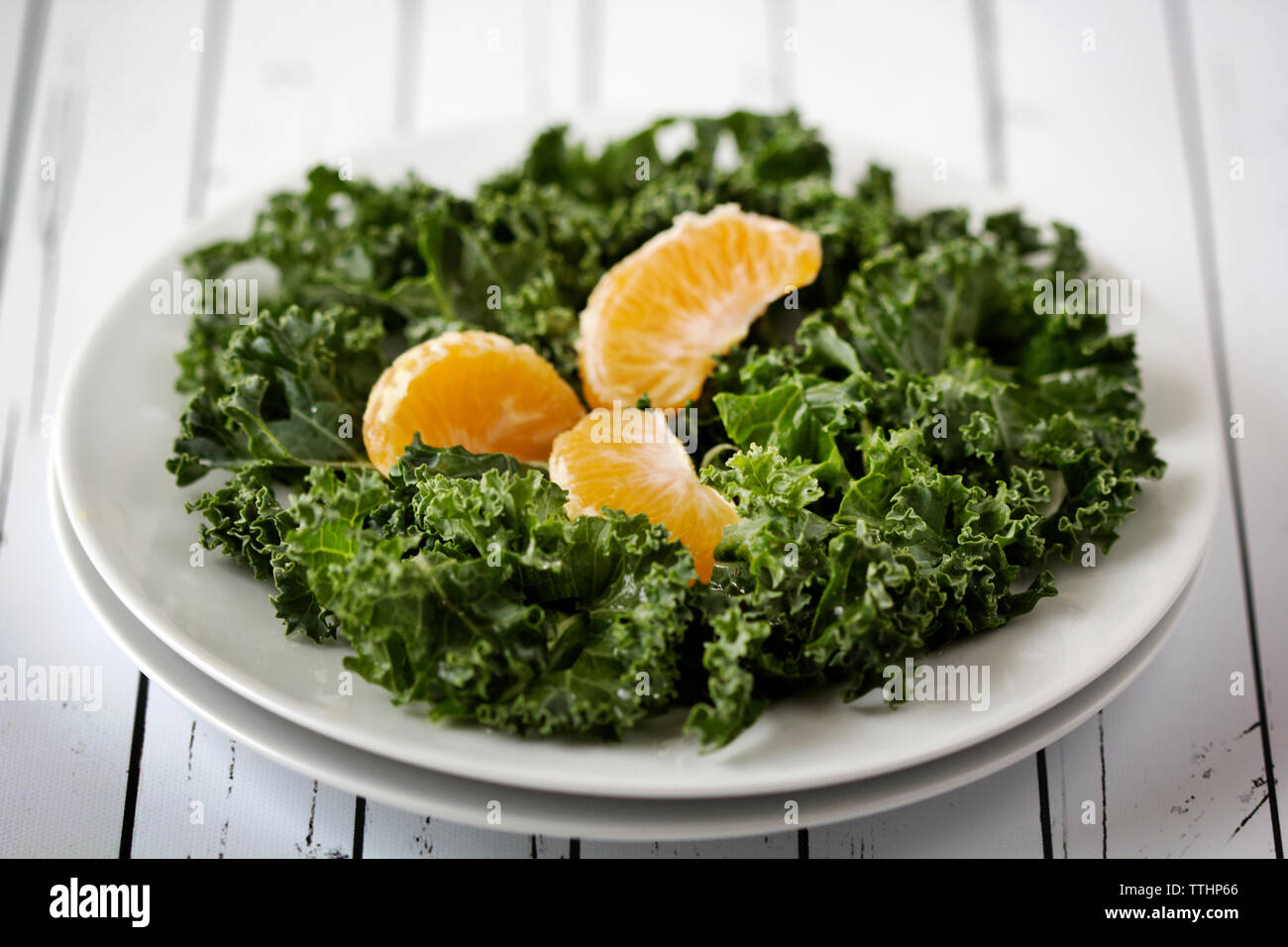 In der Nähe von Kale und orange in der Platte auf dem Tisch Stockfoto
