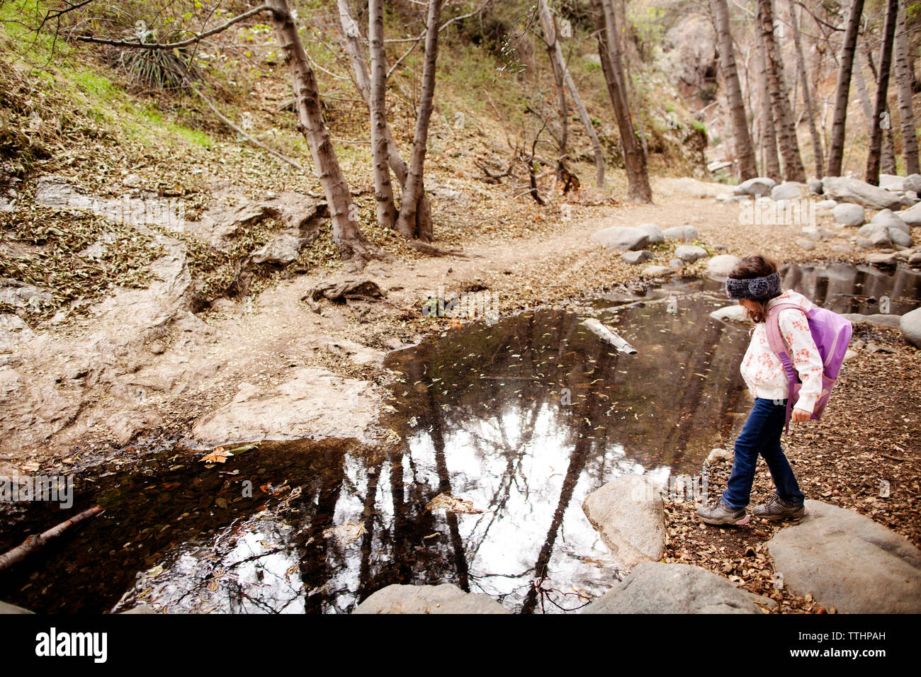 Stehendes Mädchen durch Wasser im Wald Stockfoto
