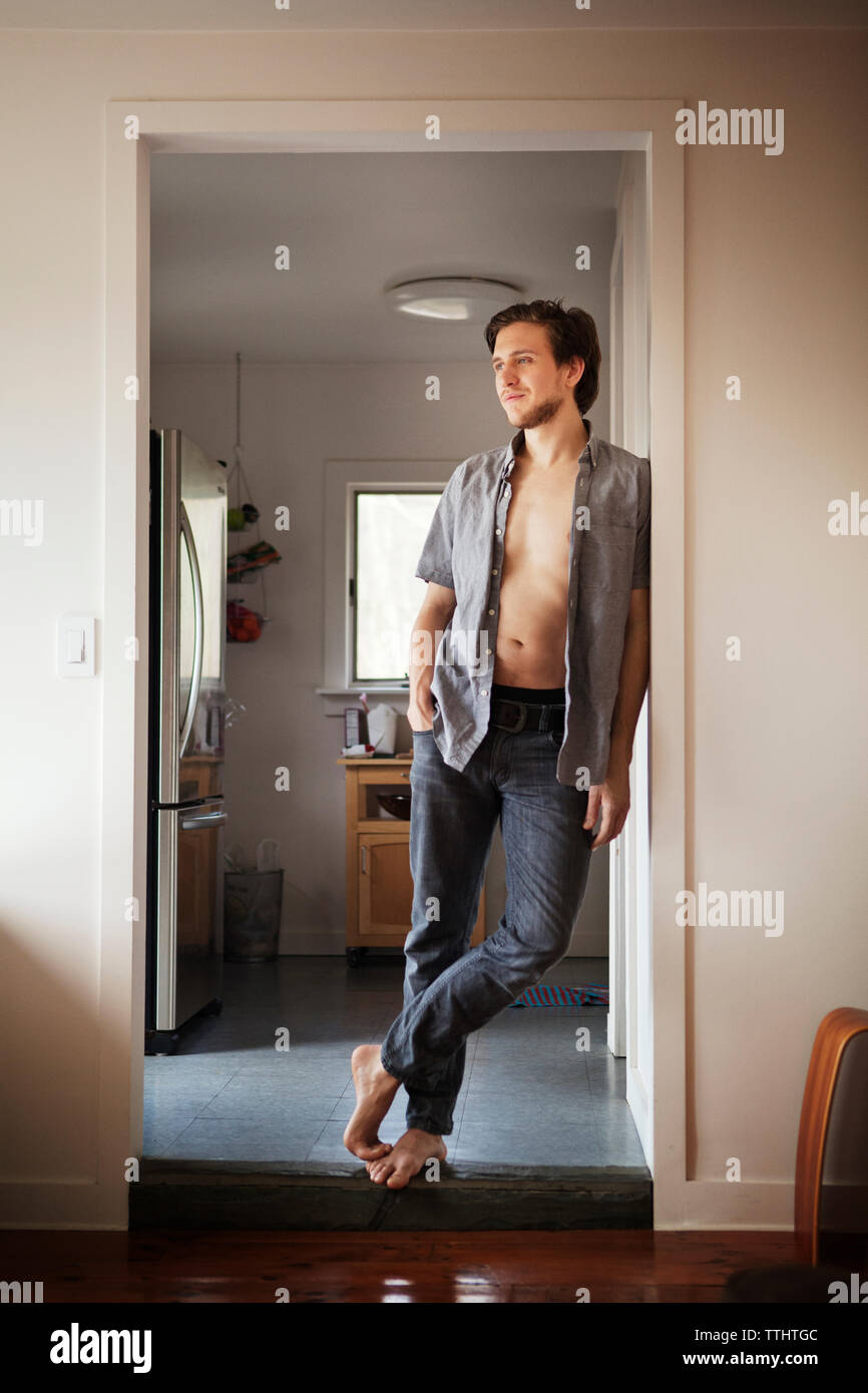 Volle Länge des Menschen auf der Tür zu Hause Schiefe Stockfoto