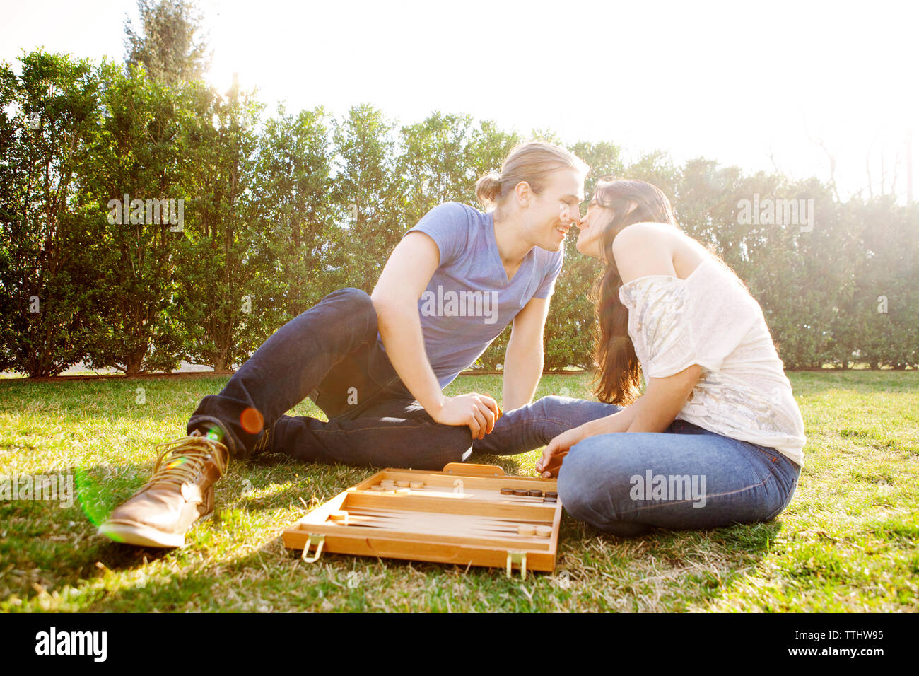 Romantisches Paar Backgammon Spiel an der Wiese Stockfoto