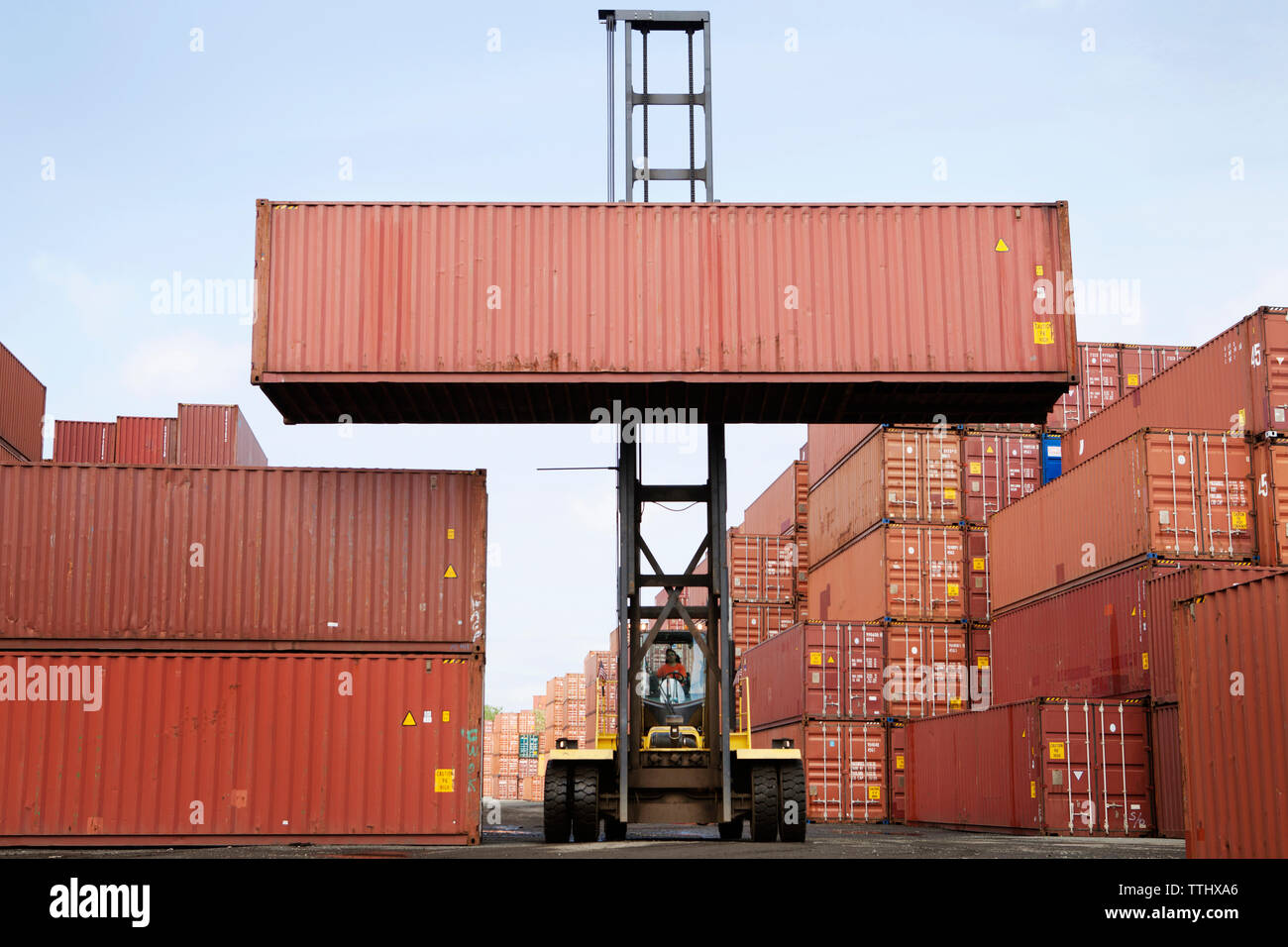 Mann anheben Cargo Container durch Gabelstapler an gewerbliche Dock Stockfoto