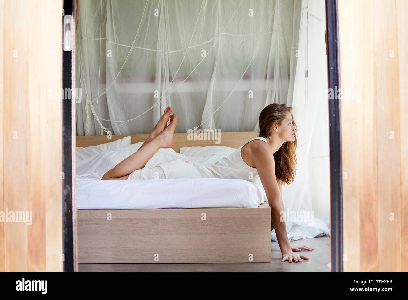 Seitenansicht der Frau liegend auf Bett zu Hause Stockfoto