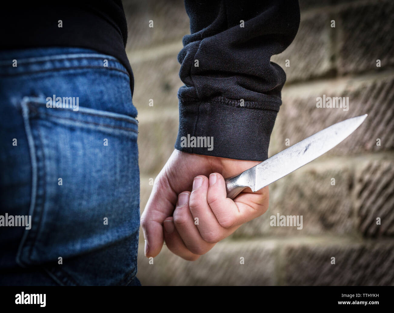 Messer Kriminalität, Teenager in der Hoody mit einem Messer auf die Straße in Großbritannien Stockfoto
