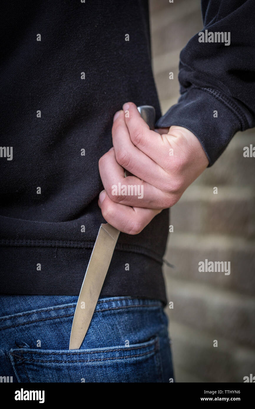 Messer Kriminalität, Teenager in der Hoody mit einem Messer auf die Straße in Großbritannien Stockfoto